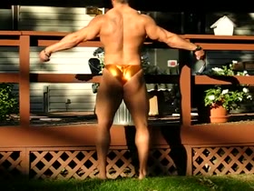 BODYBUILDER POSING AND FLEXING IN GOLD TRUNKS