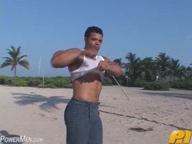 Young bodybuilder posing at the shore