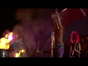 Tim Capello playing a saxophone shirtless