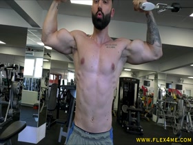 Tattooed muscle guy pumps biceps