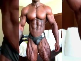 Big Black Muscle Man Posing In His Bed Room